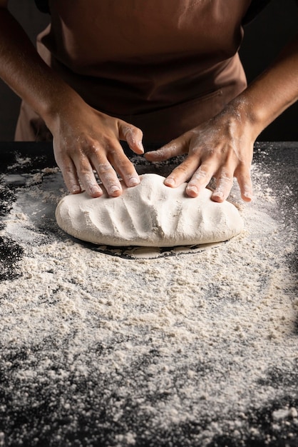 Il cuoco impastando la pasta sul tavolo