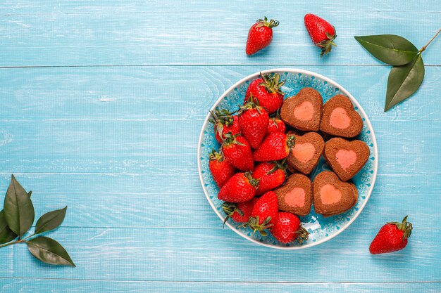 Il cuore ha modellato i biscotti con le fragole fresche, vista superiore della fragola e del cioccolato