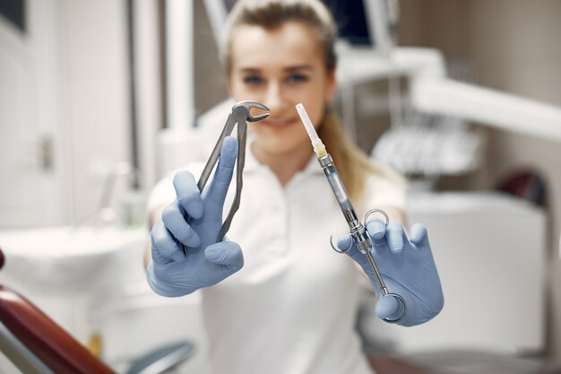 Il dentista si sta preparando per il ricevimento. Medico con il suo strumento. Donna che guarda la telecamera