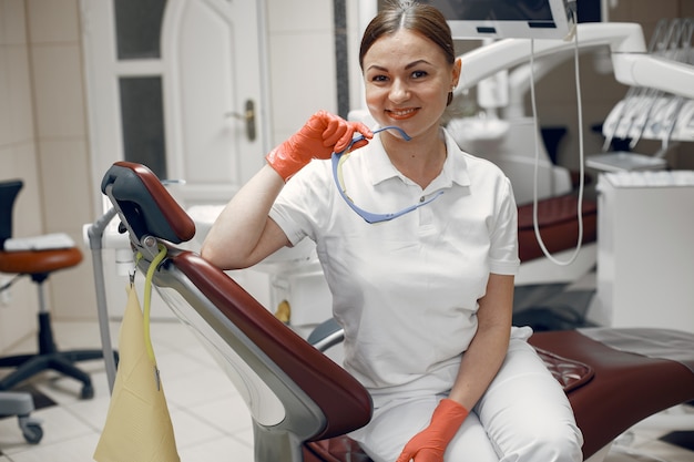 Il dottore tiene gli occhiali. Donna che guarda la telecamera Il dentista sta aspettando il paziente