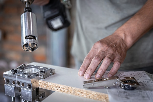 Il falegname lavora con uno strumento di perforazione di precisione professionale.