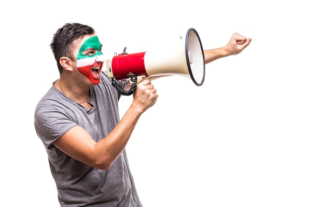 Il fan fedele del sostenitore dell'uomo bello del fronte della bandiera dipinta della squadra nazionale dell'Iran ottiene la vittoria felice che grida nel megafono con la mano appuntita. Fans le emozioni.