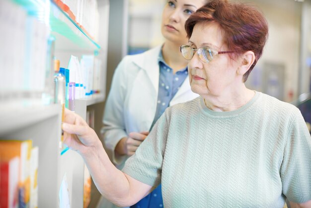 Il farmacista aiuta una donna anziana con la prescrizione