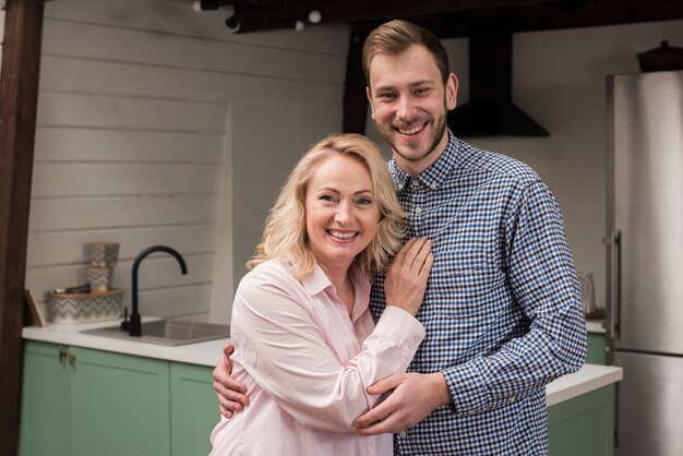 Il figlio e la madre posano felicemente in cucina