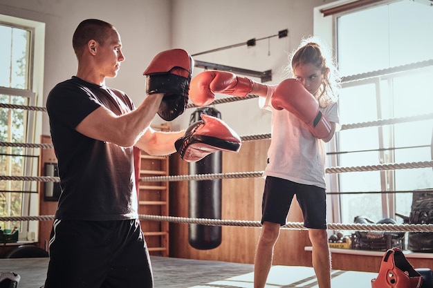 Il giovane allenatore di pugili sta allenando una nuova ragazza pugile per competizioni speciali.