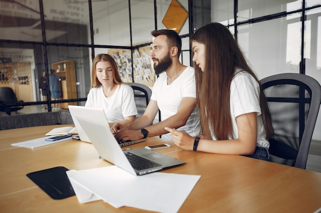 Il giovane gruppo che lavora insieme e usa il computer portatile