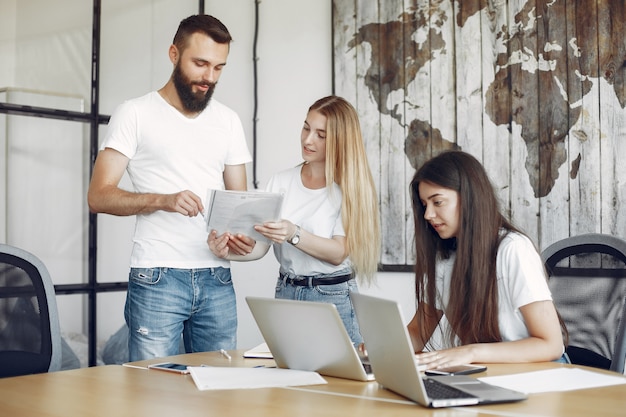 Il giovane gruppo che lavora insieme e usa il computer portatile