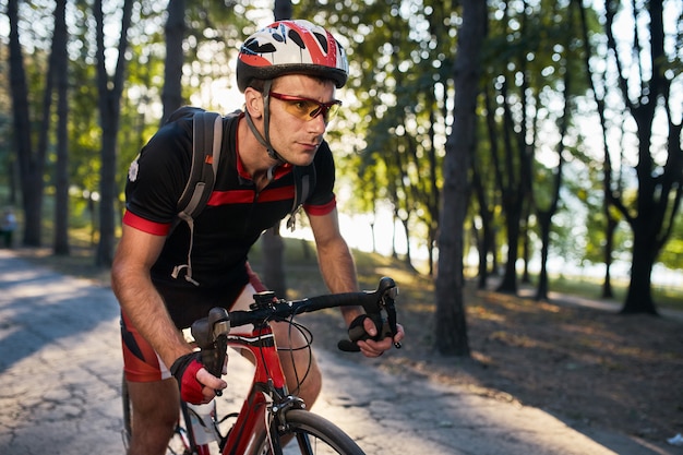 Il giovane sta pedalando in bici da strada la sera