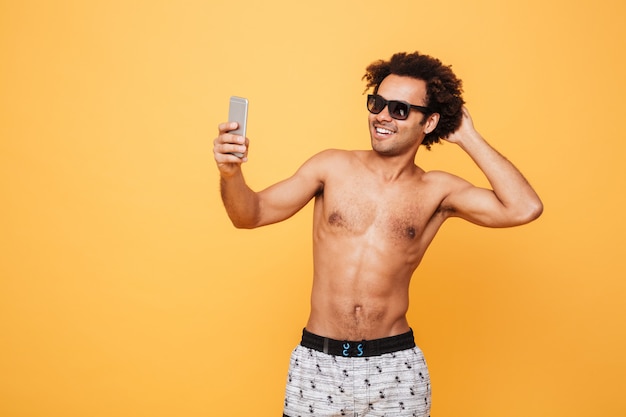 Il giovane uomo africano emozionale bello fa il selfie