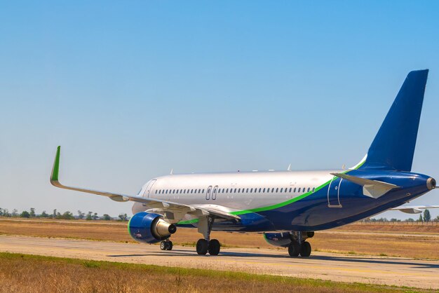 Il grande aereo passeggeri guida lungo la pista dell'aeroporto