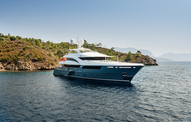 Il grande yacht di lusso rimane nel mare intorno all&#39;isola su uno sfondo di cielo