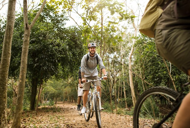 Il gruppo di amici guida insieme la mountain bike nella foresta