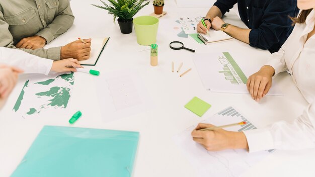 Il gruppo di persone di affari consegna lo scrittorio bianco