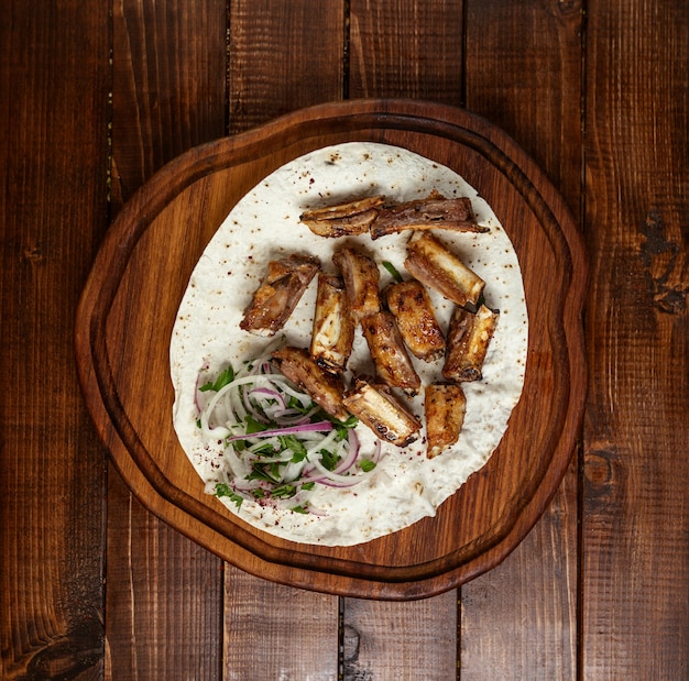 Il kebab della carne ha messo sulla vista superiore del bordo di legno