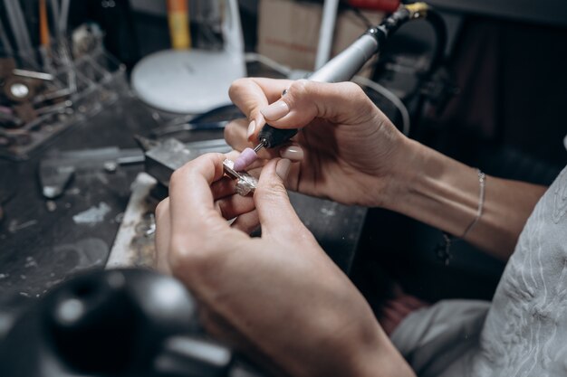 Il maestro elabora il metallo prezioso nell'officina domestica