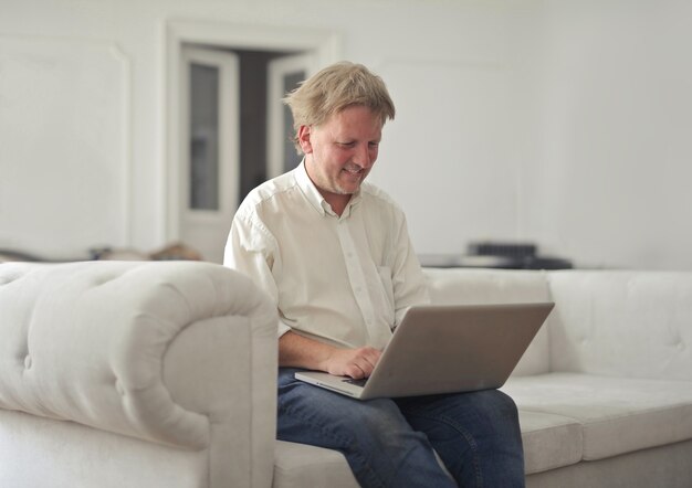 Il maschio lavora con un laptop a casa