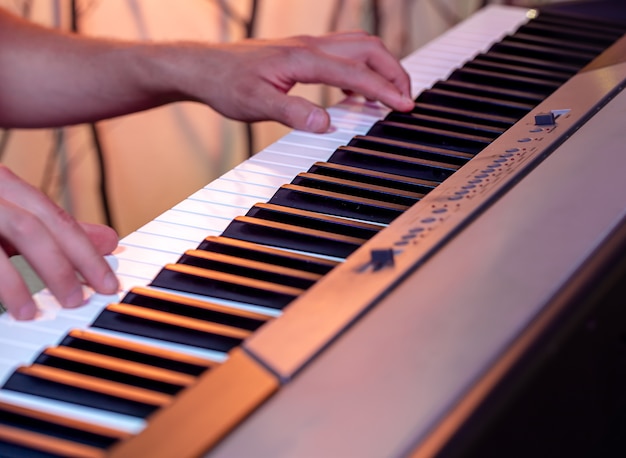 Il maschio passa sui tasti di un pianoforte