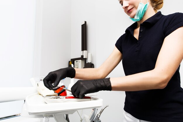 Il medico lavora con attrezzature e strumenti dentali nell&#39;ambulatorio del dentista. Close-up di strumenti.