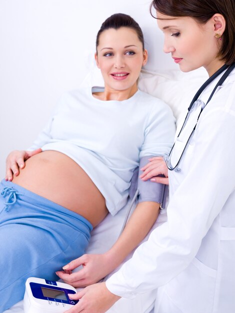 Il medico misura la pressione arteriosa alla donna incinta