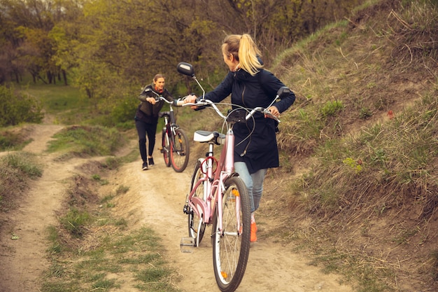 Il migliore amico si diverte vicino al parco di campagna sul mare, in sella a biciclette