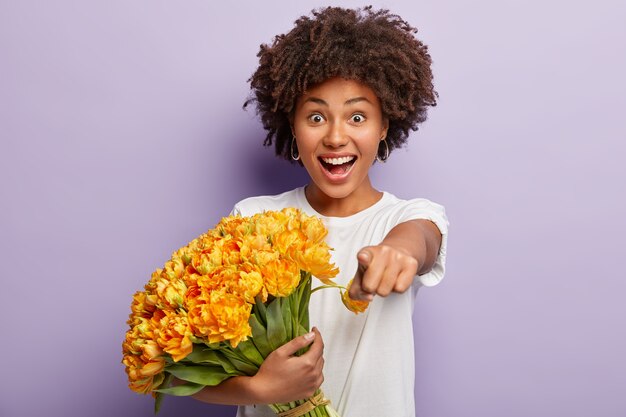 Il modello femminile ha un taglio di capelli afro, un'espressione del viso felicissima, indica direttamente la telecamera, esprime la scelta