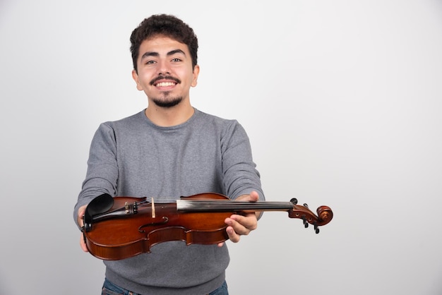 Il musicista suona il violino e sembra ispirato e positivo.