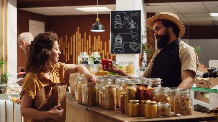 Foto gratuito il negoziante di un negozio di alimentari aiuta il cliente