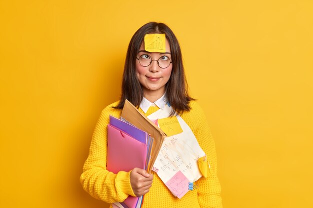 Il nerd femminile intelligente divertente attraversa gli occhi ha un adesivo con grafica disegnata sulla fronte