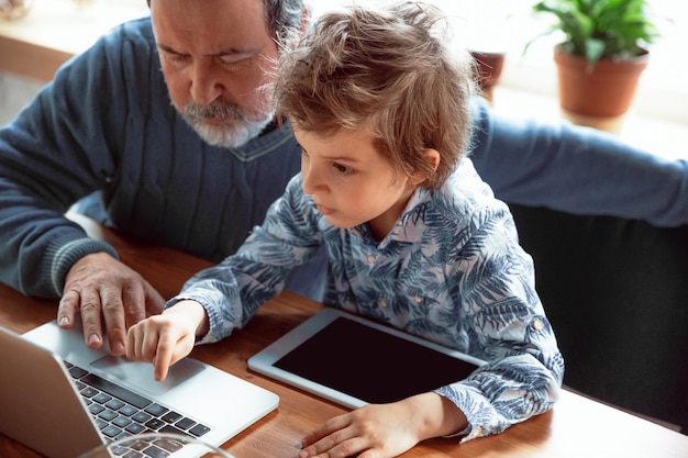 Il nonno e il nipote trascorrono del tempo isolati a casa, si divertono, si prendono cura delle piante, innaffiano