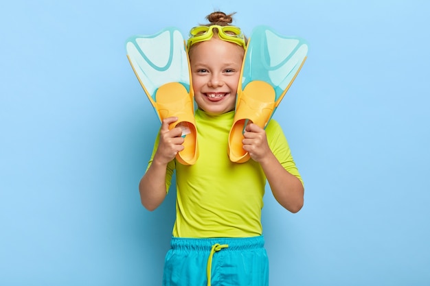 Il nuotatore della bambina indossa gli occhiali di protezione, tiene le pinne