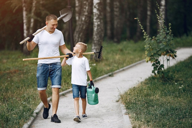 Il padre con il piccolo figlio sta piantando un albero su un parco