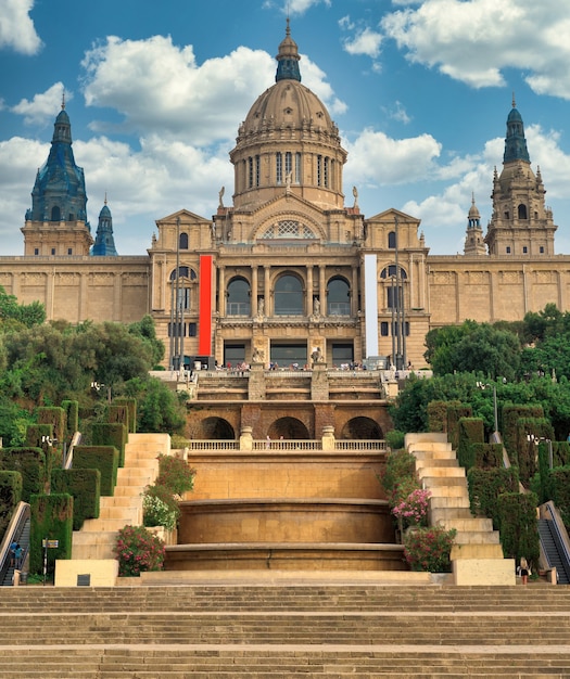 Il Palau National di Barcellona, in Spagna, giardini e persone di fronte ad esso. Cielo nuvoloso