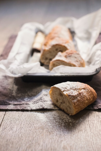 Il pane al forno di recente dimezzato ha spolverato con farina sul tavolo di legno