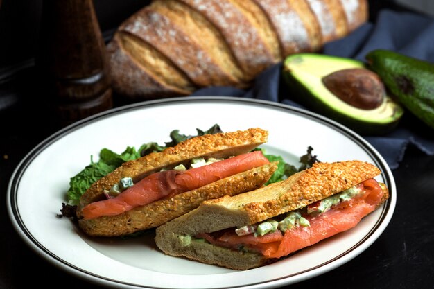 Il panino al salmone affumicato con avocado in salsa è servito nel pane con sesamo