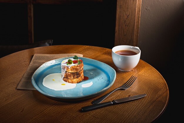 Il piatto con gustose frittelle sul tavolo di legno