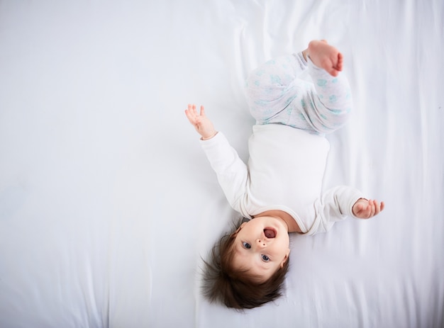 Il piccolo bambino giace sul letto