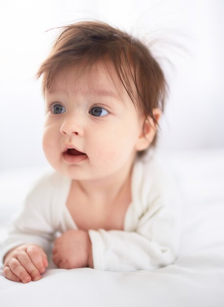 Il piccolo bambino giace sul letto