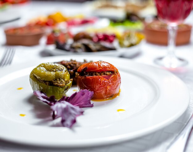 Il pomodoro e la melanzana tradizionali del peperone dolce di dolma del piatto tre hanno riempito dalla vista laterale della carne tritata