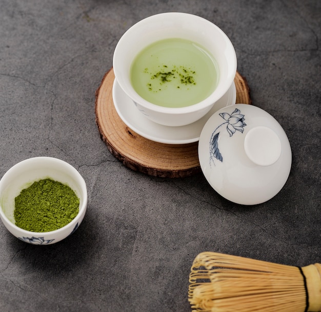 Il primo piano della tazza di tè di matcha con bambù sbatte