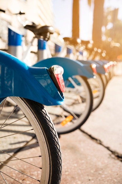 Il primo piano delle biciclette sta in una fila su un parcheggio per affitto