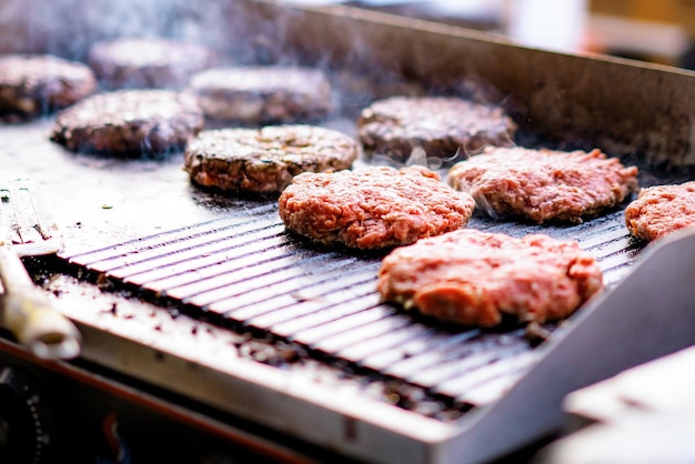 Il processo di cottura alla griglia per preparare le cotolette di carne per gli hamburger. Cotoletta di cheeseburger