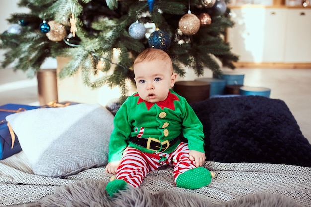 Il ragazzino si siede su un albero di Natale