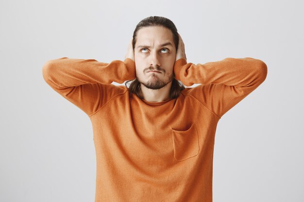 Il ragazzo accigliato matto chiudeva le orecchie, alzando lo sguardo arrabbiato con i vicini