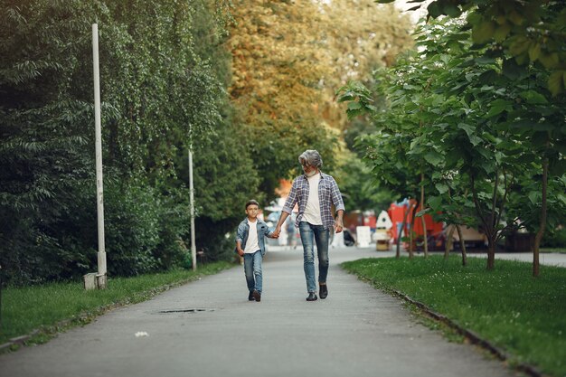 Il ragazzo e il nonno stanno camminando nel parco. Uomo anziano che gioca con il nipote.
