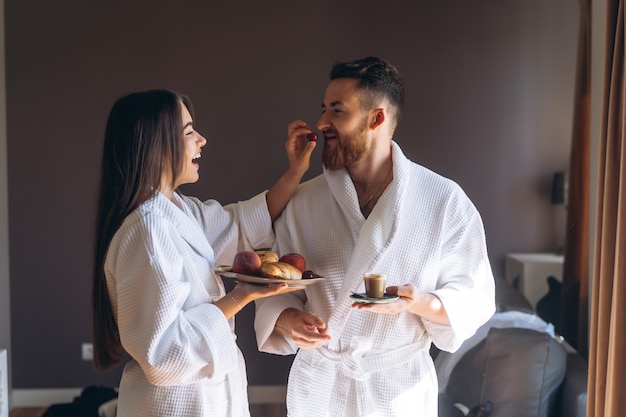 Il ragazzo e la ragazza accappatoio, la ragazza nutre il ragazzo frutta