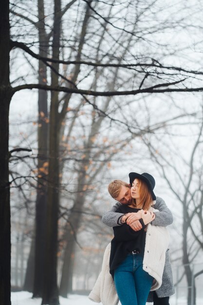 Il ragazzo e la ragazza riposano nella foresta invernale.