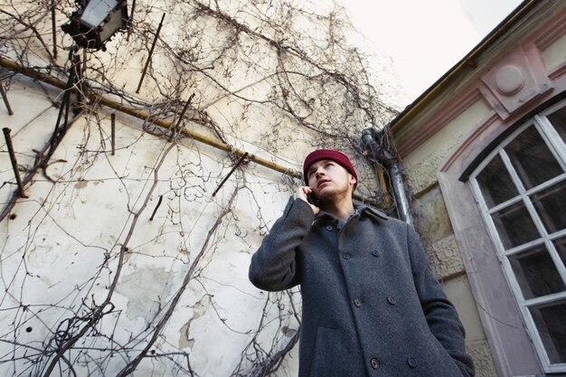 Il ragazzo in cappotto rosso sembra occupato a parlare al telefono