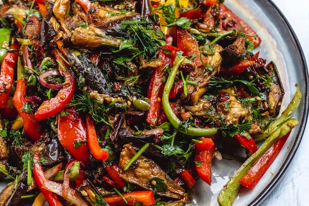 Il ragù di verdure di vista laterale ha stufato la cipolla di melanzana inverdisce il pomodoro verde ed il peperone su un piatto