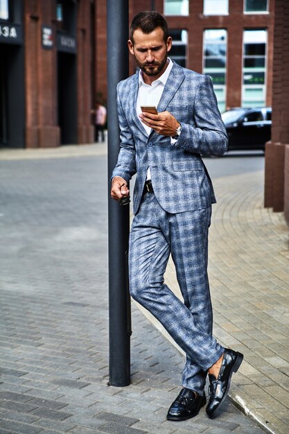 Il ritratto del modello bello dell'uomo d'affari di modo si è vestito in vestito a quadretti elegante