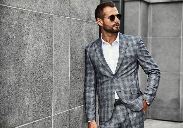 Il ritratto del modello bello dell'uomo d'affari di modo si è vestito in vestito a quadretti elegante